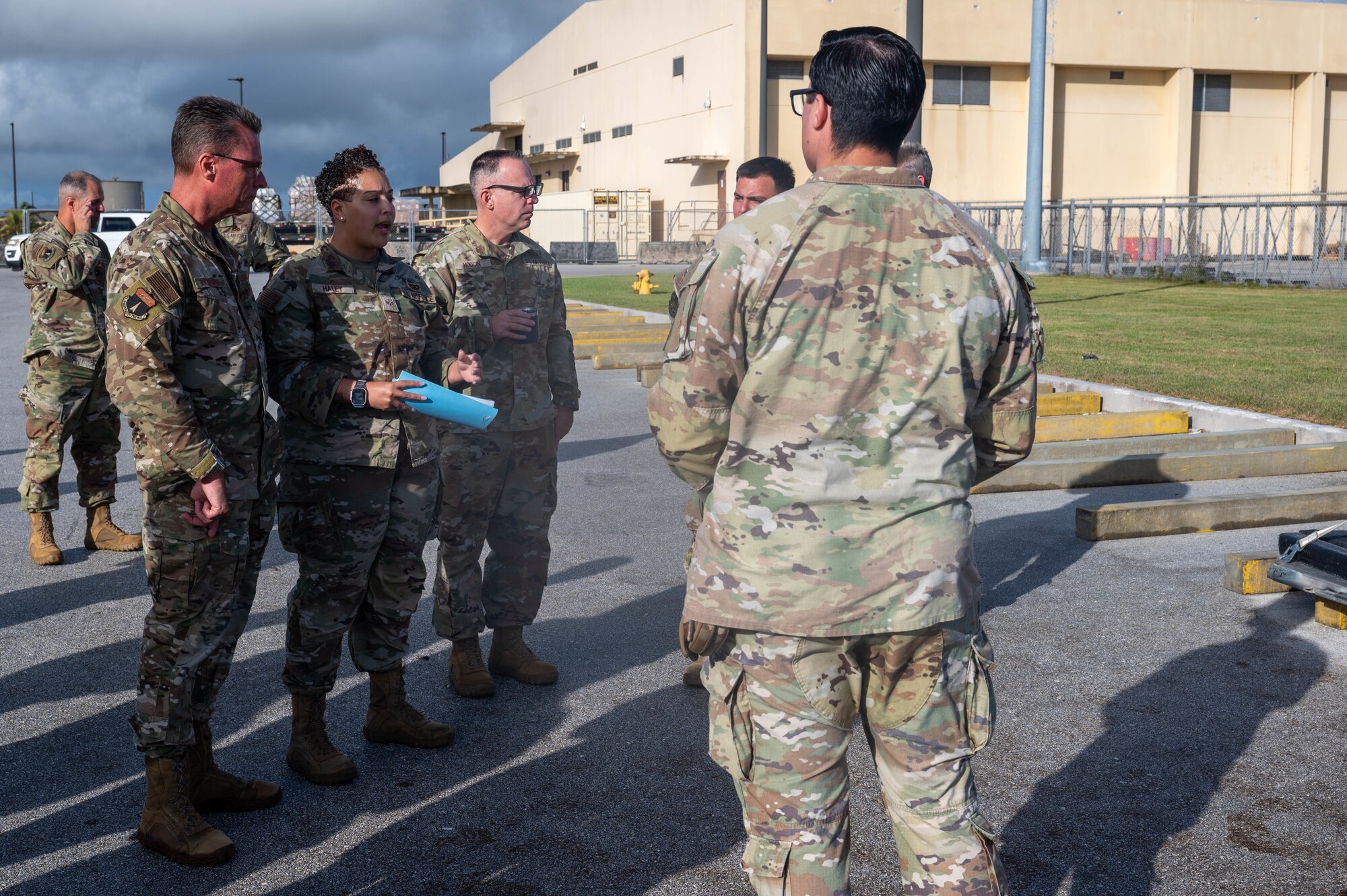 U.S. Air Force Senior Airman Charles Laffon and Senior Airman Acadia Haley, special planning technicians with the 734th Air Mobility Squadron, brief U.S Air Force Brig. Gen. Thomas Palenske, commander of the 36th Wing, and Chief Master Sgt. Timothey Hodgin, command chief of the 36th Wing, on the processes leading up to the joint inspection that happens in the cargo flow process on Andersen Air Force Base, Guam, Feb. 10. 2025. The Joint Inspection Demo held by the 734th AMS team includes an example of a correctly built cargo pallet and a cargo pallet with discrepancies from past exercises found during typical processing. (U.S. Air Force Photo by Airman 1st Class Allon Lapaix)