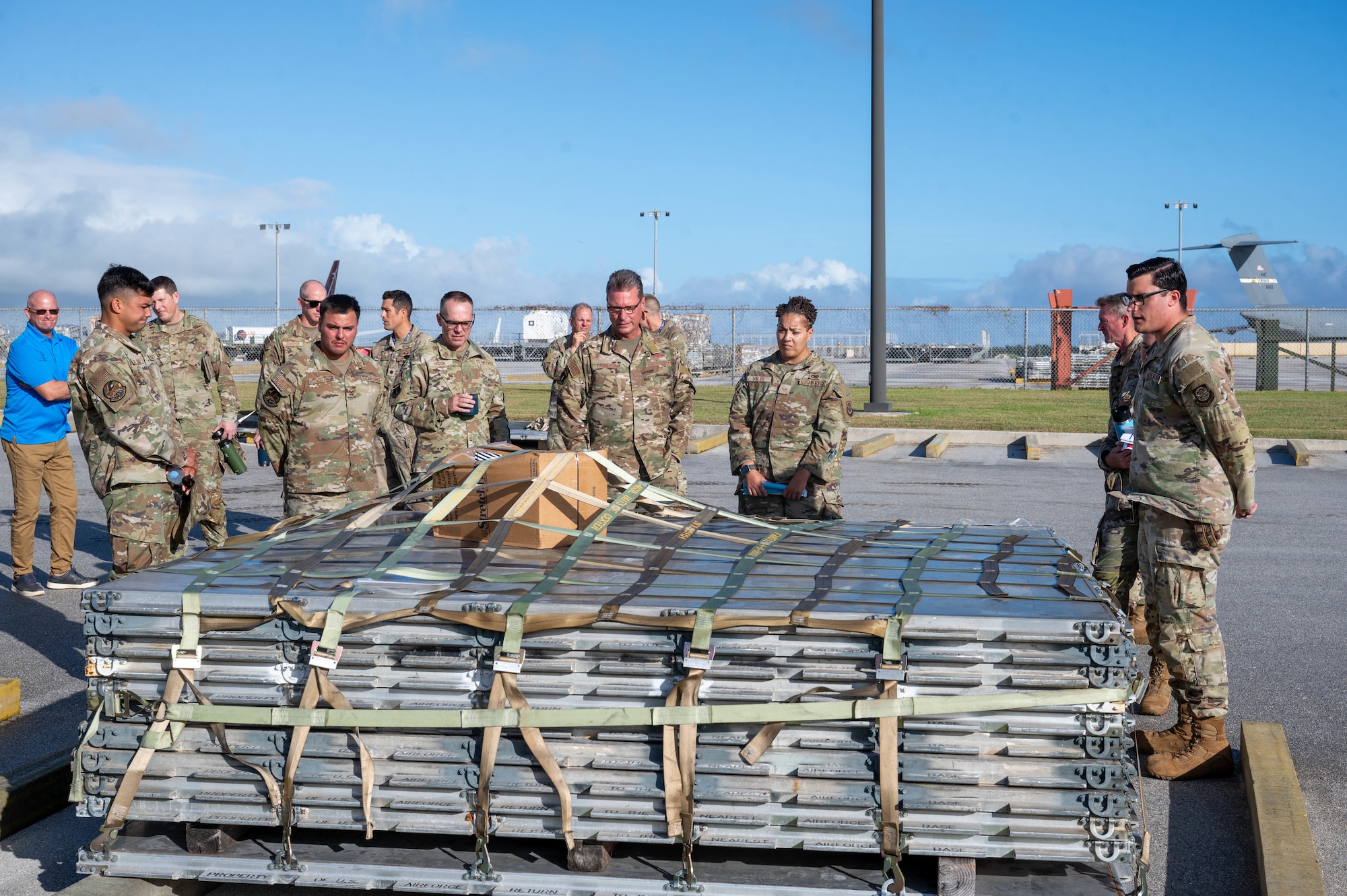U.S. Air Force Senior Airman Charles Laffon and Senior Airman Acadia Haley, special planning technicians with the 734th Air Mobility Squadron, brief U.S Air Force Brig. Gen. Thomas Palenske, commander of the 36th Wing, and Chief Master Sgt. Timothey Hodgin, command chief of the 36th Wing, on the processes leading up to the joint inspection that happens in the cargo flow process on Andersen Air Force Base, Guam, Feb. 10. 2025. The Joint Inspection Demo held by the 734th AMS team includes an example of a correctly built cargo pallet and a cargo pallet with discrepancies from past exercises found during typical processing. (U.S. Air Force Photo by Airman 1st Class Allon Lapaix)