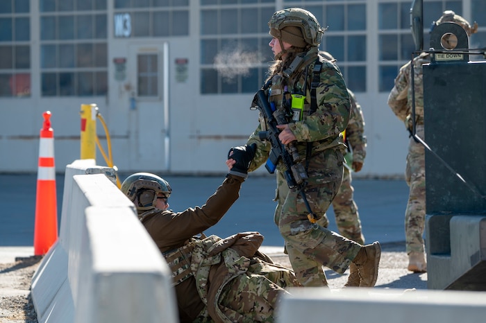 A U.S. Airman helps another Airman with a simulated injury to their feet