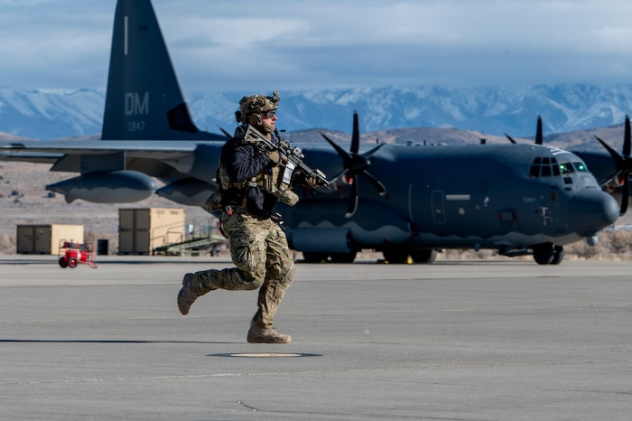 A U.S. Airman runs toward simulated gunfire during