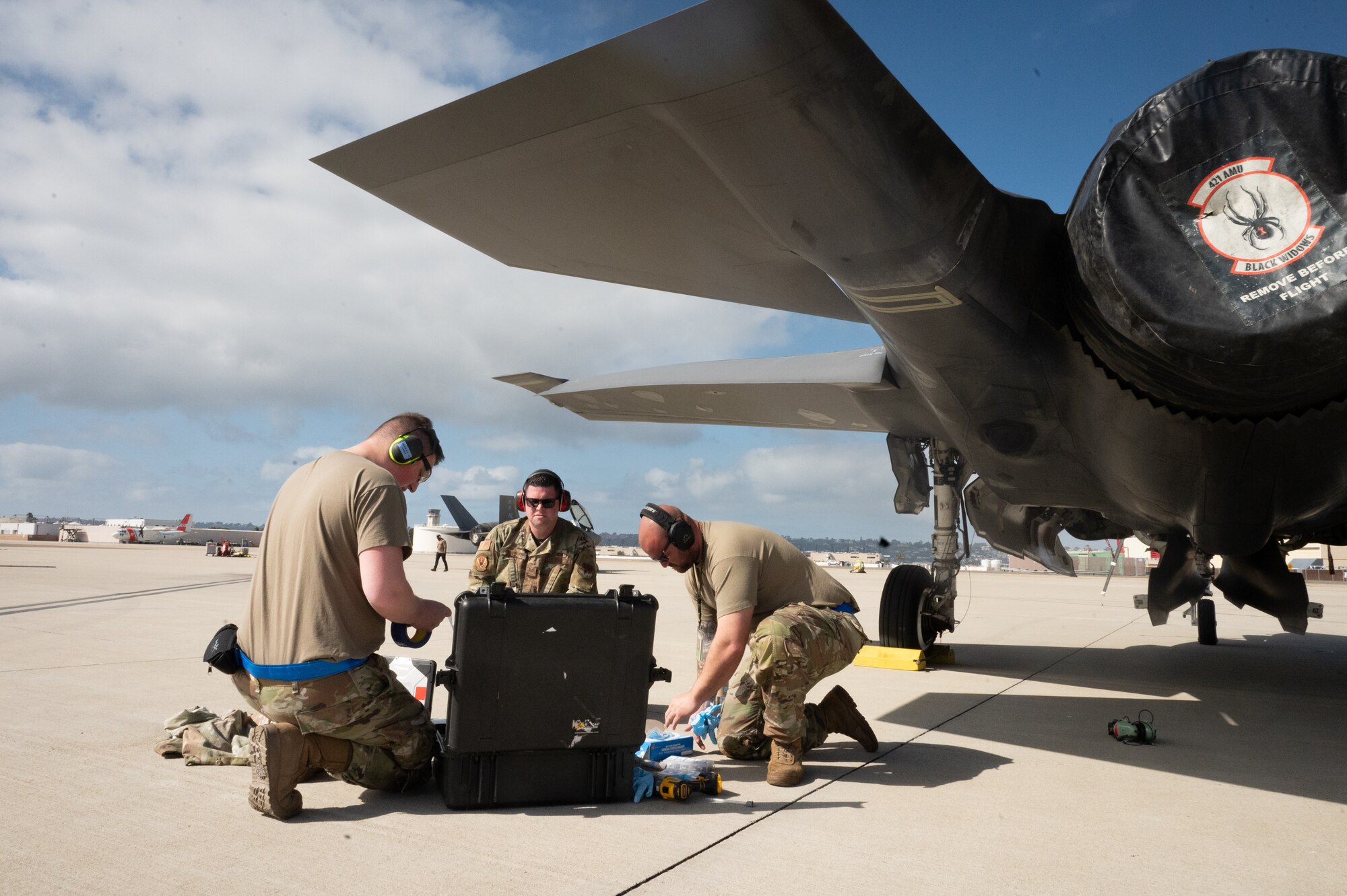 A photo of aircraft maintainers working on a jet