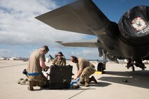 A photo of aircraft maintainers working on a jet