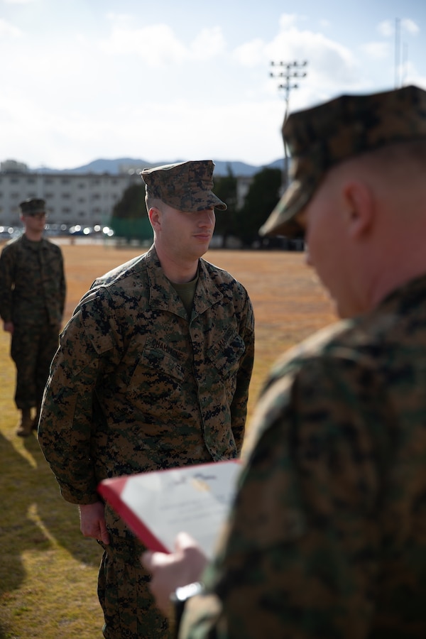 U.S. Marine Corps Lance Cpl. Brandon Champagne, an air traffic controller with Headquarters and Headquarters Squadron, Marine Corps Air Station Iwakuni, and a Florida native, stands at attention during a Navy and Marine Corps Achievement Medal award ceremony at MCAS Iwakuni, Japan, Jan. 29, 2025. Lance Cpl. Champagne received the Navy and Marine Corps Achievement Medal for rescuing two individuals trapped in wreckage after a vehicle accident while home on leave. (U.S. Marine Corps photo by Cpl. Colin Thibault)