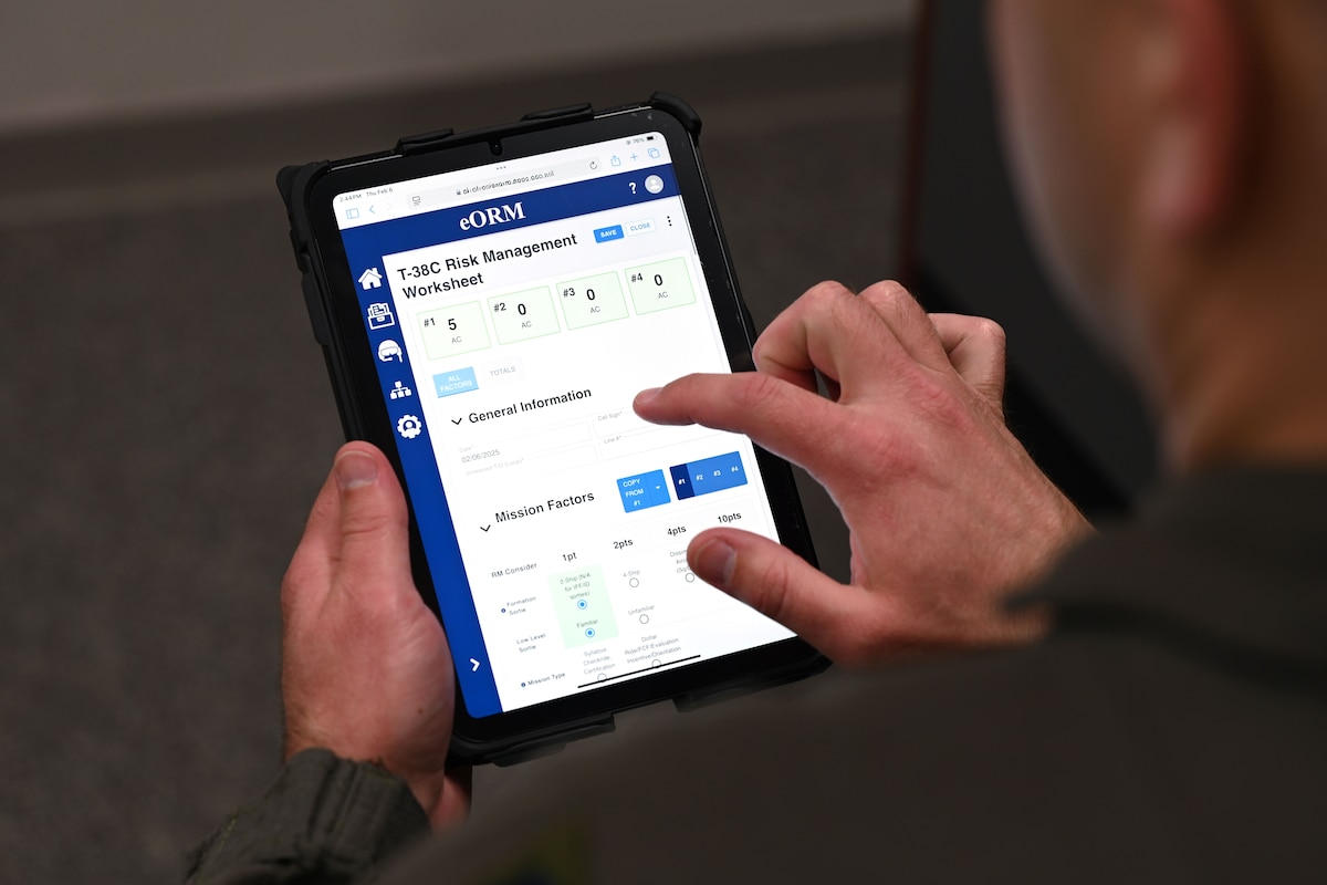 A T-38 instructor pilot pulls up a T-38 Risk Management Worksheet on the eORM app during a pre-flight brief. The eORM app enhances the risk assessment process for aircrews before every flight. It also gives flying unit commanders a clearer picture of aviation risks for each mission. (This photo has been altered for security purposes by obscuring the web address.)