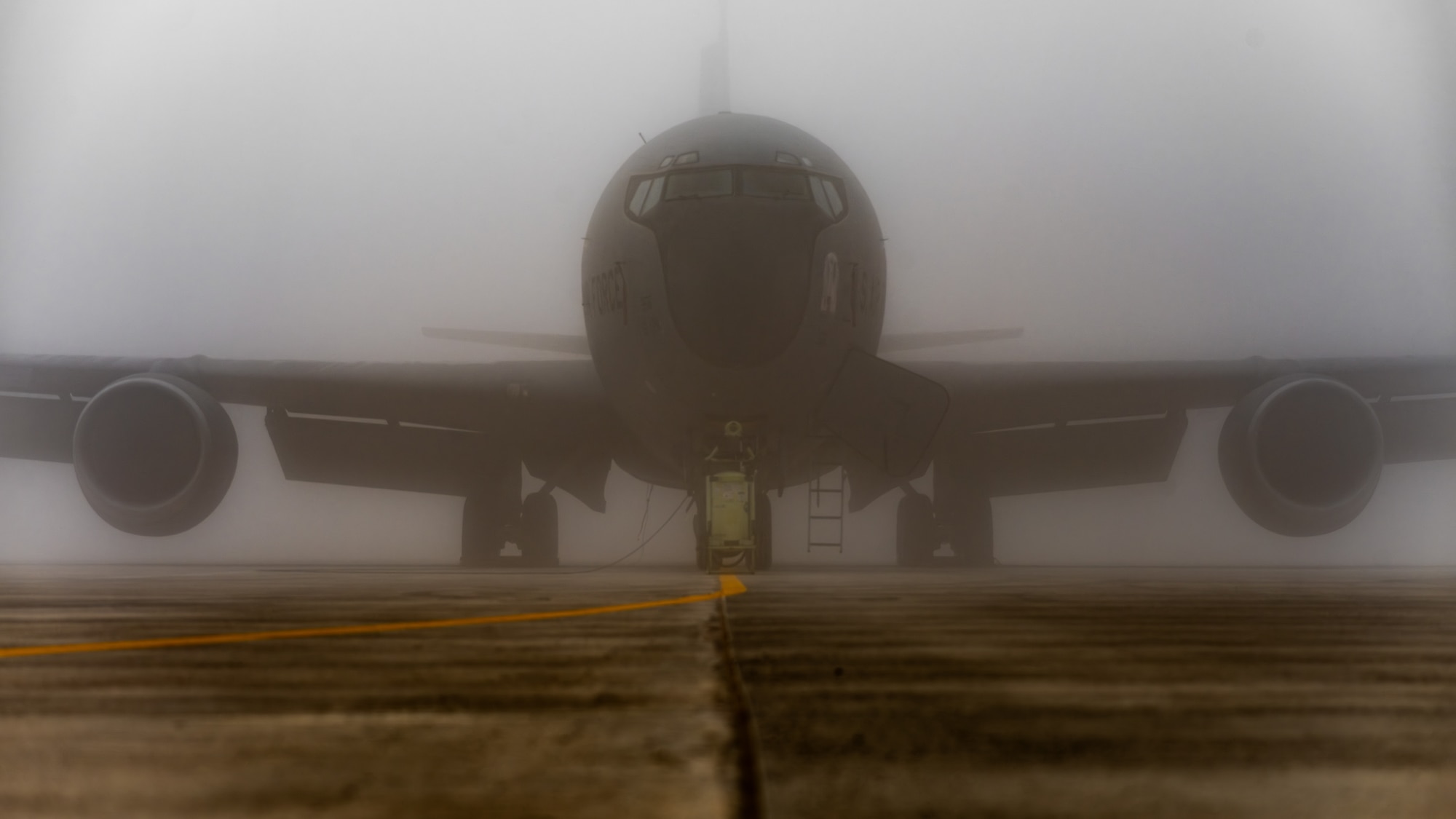 A KC-135 sits in the fog
