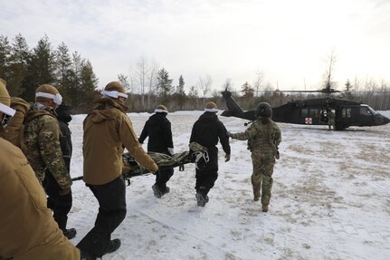 U.S. Navy explosive ordnance disposal (EOD) technicians assigned to Explosive Ordnance Disposal Mobile Unit (EODMU) 2 conduct Tactical Combat Casualty Care (TCCC) and medical evacuation (MEDEVAC) training during the Snow Crab exercise in Little Falls Minnesota.