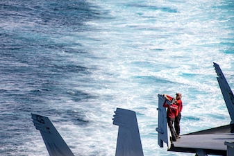 Sailors maintain an F/A-18E Super Hornet aboard USS Carl Vinson (CVN 70) in the Sibutu Passage.