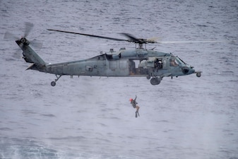 An MH-60S Sea Hawk helicopter from HSC-4 conducts search and rescue training in the Celebes Sea.