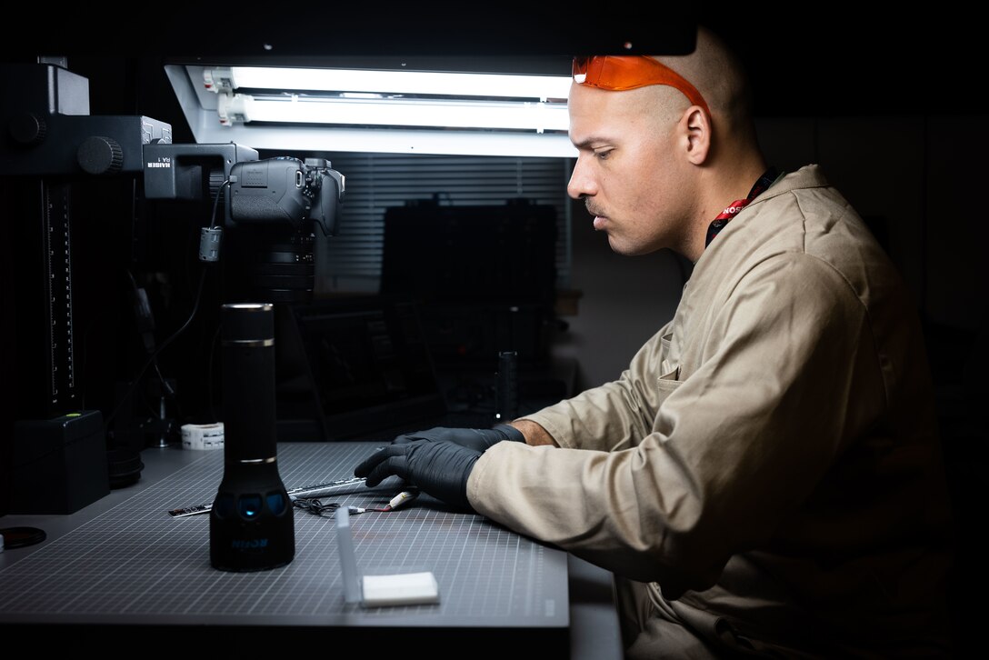 U.S. Marine Corps Staff Sgt. Bryan Bell, a criminal investigator with the 22nd Marine Expeditionary Unit, prepares to photograph a sample during Marine Air-Ground Task Force (MAGTF) Interoperability Exercise, on Marine Corps Base Camp Lejeune, North Carolina, Feb. 6, 2025. The raid is one of several training events within MAGTF Interoperability, a course conducted by Expeditionary Operations Training Group. This course is designed to evaluate integrated elements of the 22nd MEU across a variety of full mission profiles in a simulated peer threat environment. (U.S. Marine Corps photo by Sgt. Nathan Mitchell)