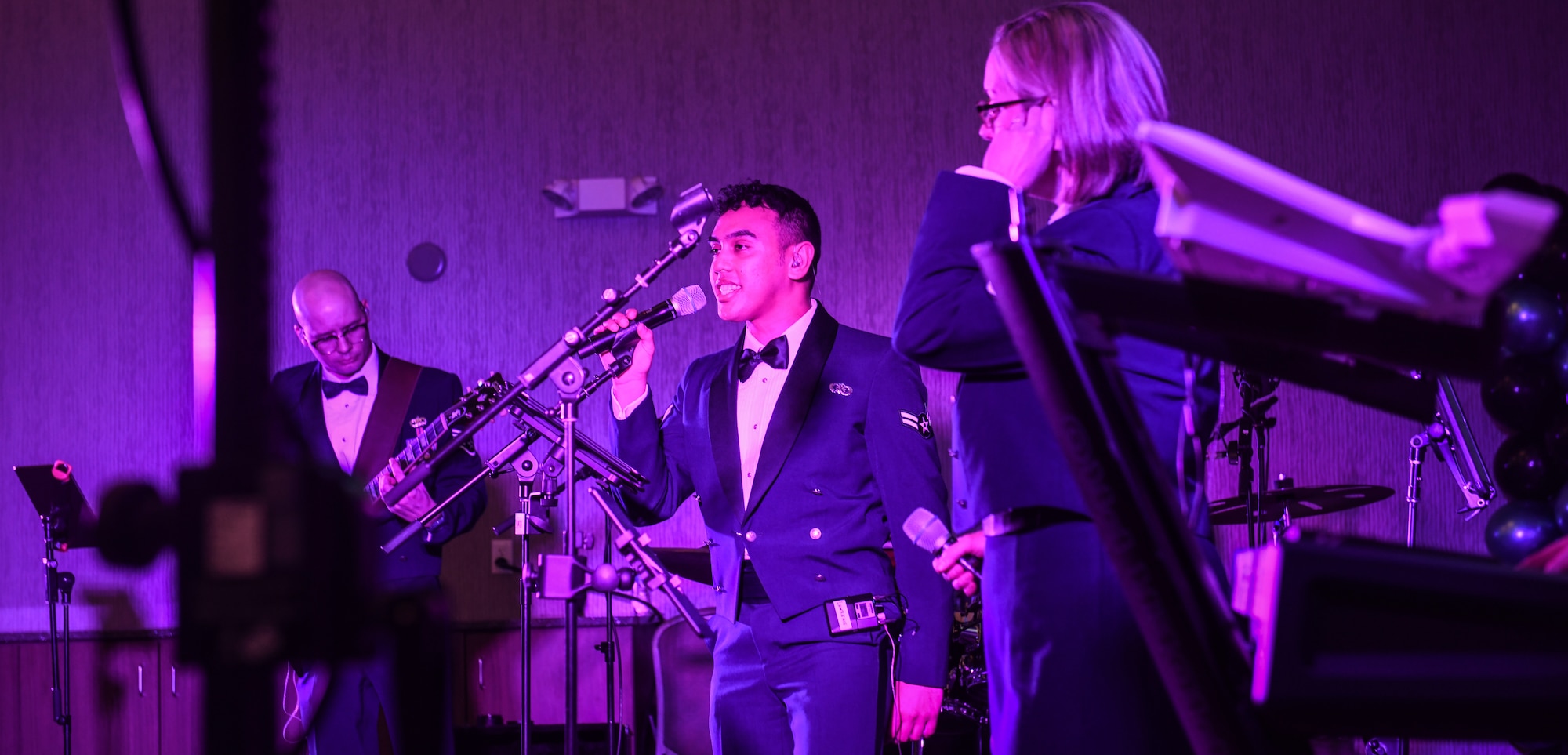 Airman 1st Class Lawrence Laureano, vocalist, United States Air Force Heartland of America band, sings rock songs at the Beardmore Event Center in Bellevue, Neb. on Feb. 8, 2024. The theme of this year's awards banquet was 80's rock. (U.S. Air Force photo by Chad Watkins)