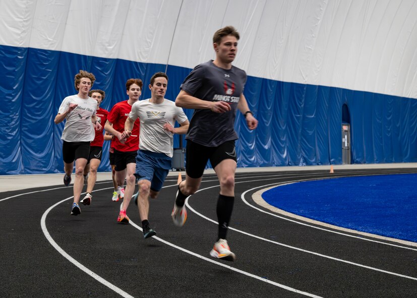 Minot State University track and field athletes run around the track during their practice in The Bubble at Minot Air Force Base, North Dakota, Feb. 11, 2025. The Bubble is a climate-controlled facility that houses a full-size track and field within. (U.S. Air Force photo by Senior Airman Kyle Wilson)