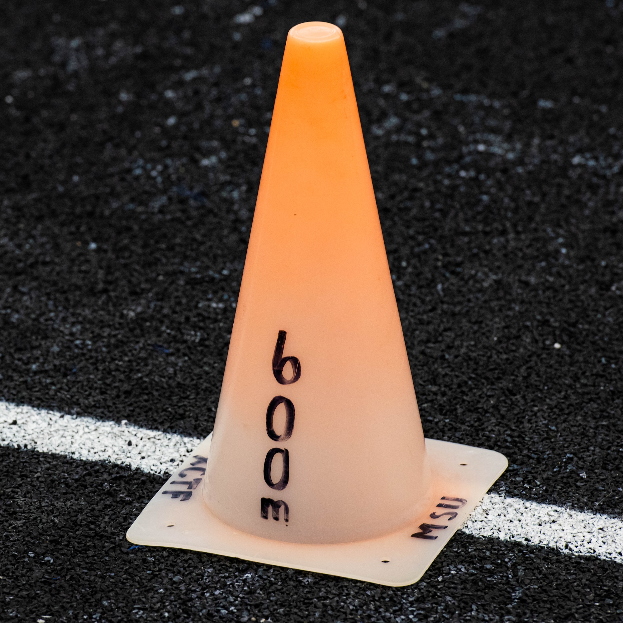 A cone is used to mark distance during the Minot State University track and field team’s practice in The Bubble at Minot Air Force Base, North Dakota, Feb. 11, 2025. The sport of track and field includes several events in which athletes compete to have the fastest time running different distances. (U.S. Air Force photo by Senior Airman Kyle Wilson)