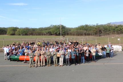 The staff of Pearl Harbor Torpedo Intermediate Maintenance Facility (PH IMA) pose for a group photo with Navy leadership after winning the inaugural Lockwood Award for Excellence in Torpedo Maintenance.