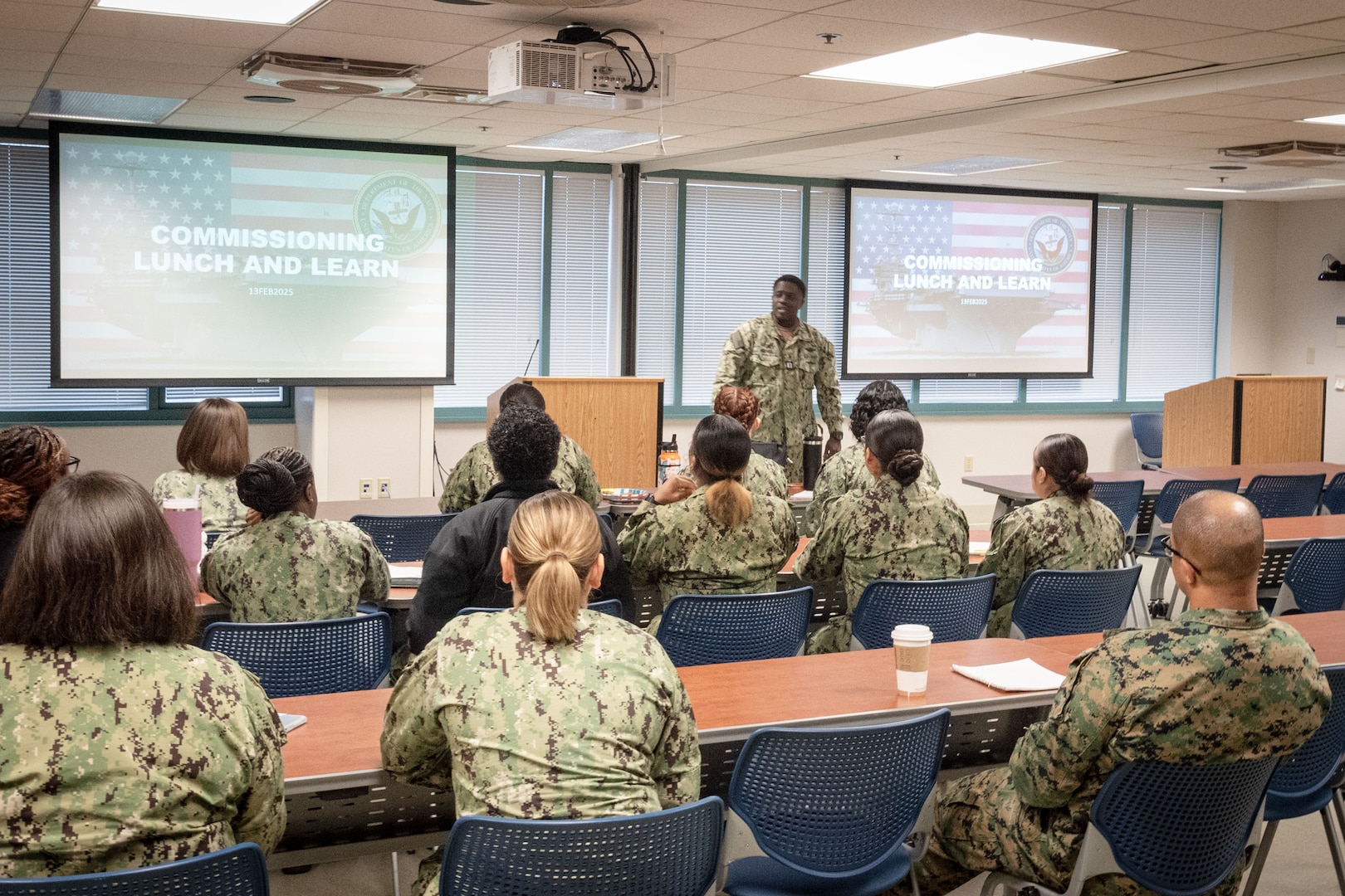 Lieutenant William Hookes, center, shares his experiences as an officer in the United States Navy during a Commissioning Lunch and Learn held February 13, 2025 aboard Naval Health Clinic Cherry Point.  The mentorship session provided information to clinic Sailors about commissioning opportunities.