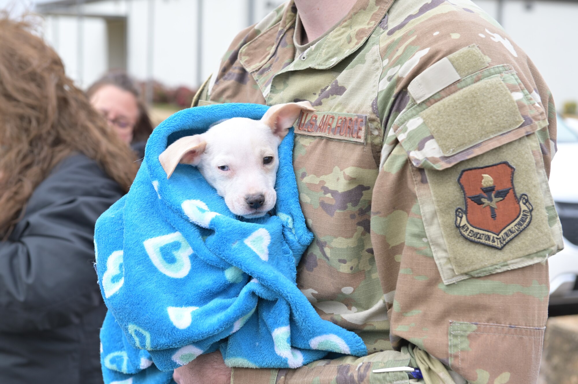 An 8-week-old puppy is held by a Service Member at the Education Center on February 13, 2024, on Columbus Air Force Base, Mississippi.