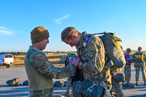 U.S. Air Force Lt. Col. Paul Martin, commander of the 290th Joint Communications Support Squadron, conducts a parachute equipment check on U.S. Army Lt. Col. Mark Saurer, commander of the Joint Communications Support Element, 2nd Squadron, prior to a static-line training jump at Brooksville Airfield, Florida, Dec. 5, 2024.