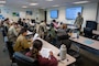 Major Osgood, Deputy Director of the Walter Reed Army Institute of Research – West, goes over the welcome letter with the Air Force trainees at peer ambassador training. 

(Photo taken by 62nd Airlift Wing Public Affairs)