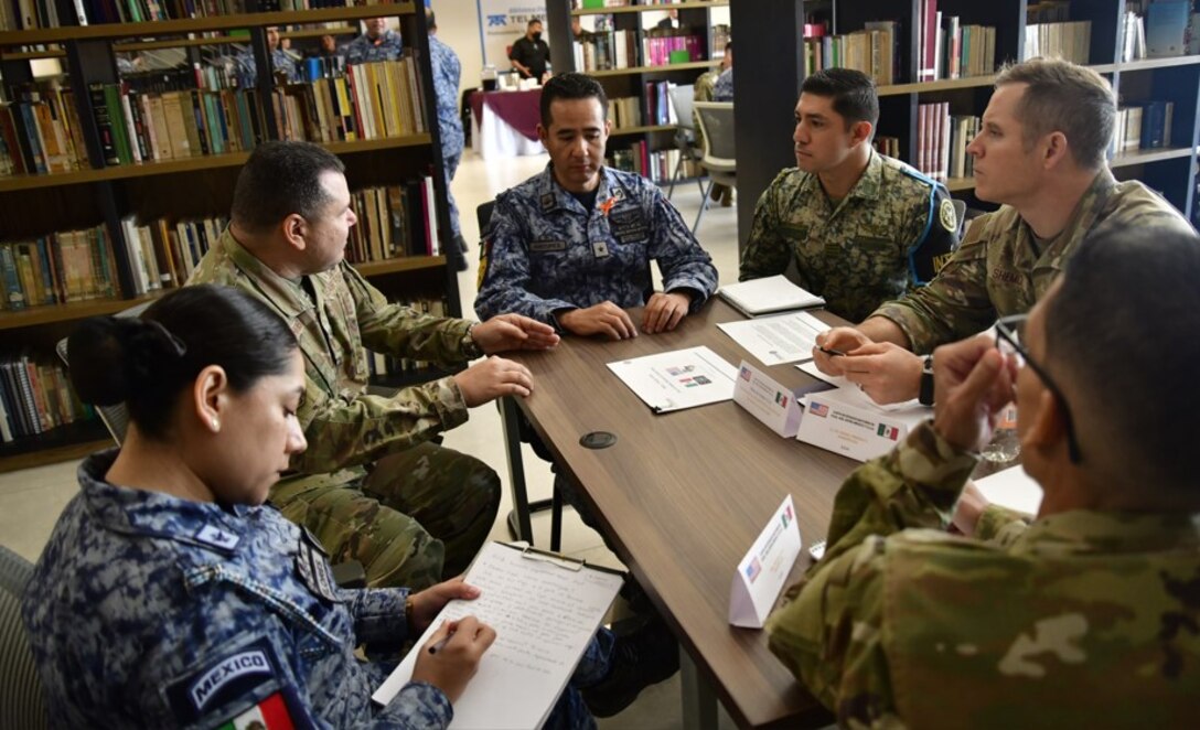 U.S. and Mexican Air Force participants sitting at a table, discussing how to strengthen their collaboration and tackle shared challenges at the 2024 Air Force Staff Talks (AFST) between the US and Mexican Air Forces.