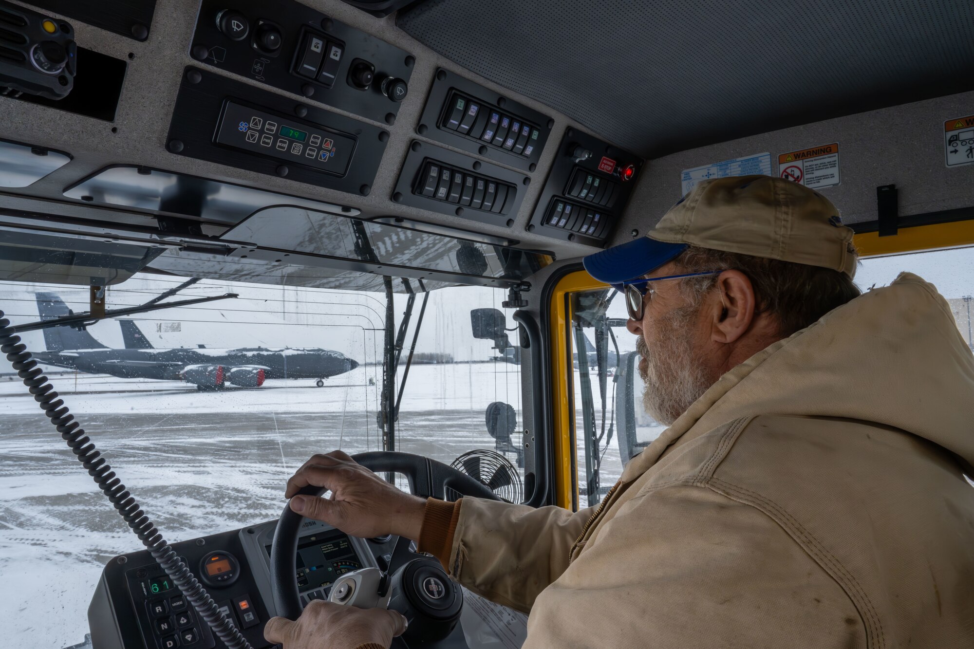 Richard Dodd, 22nd Civil Engineer Squadron heavy equipment operator, drives a snow removal vehicle at McConnell Air Force Base, Kansas, Feb. 12, 2025. The engineering equipment operators used snow plows, blowers and brooms to clear snow on base. (U.S. Air Force photo by Airman 1st Class Paula Arce)
