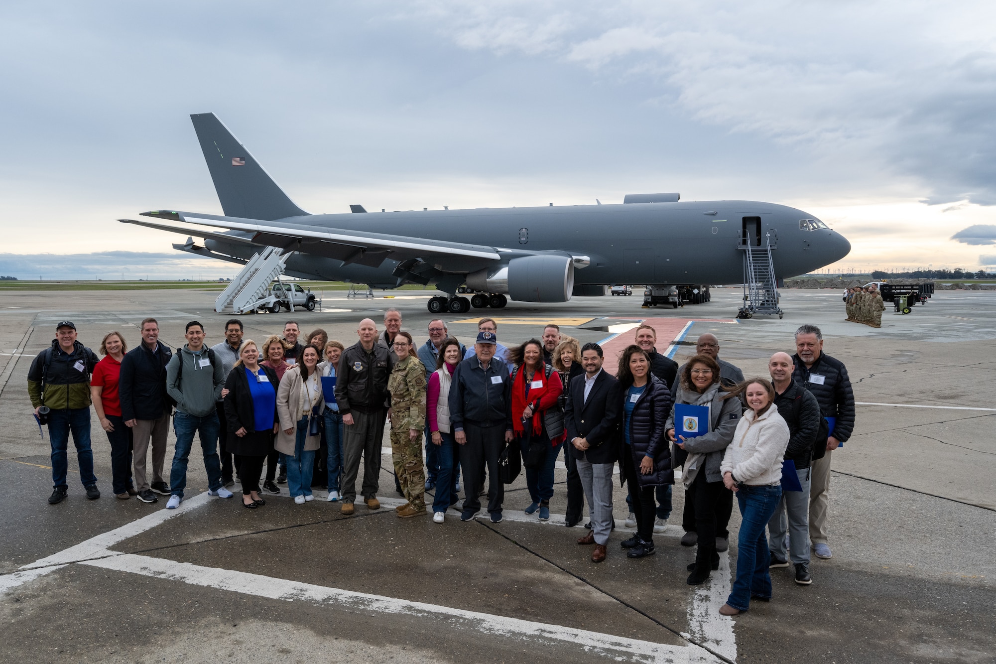 Civic leaders stand in front of plane