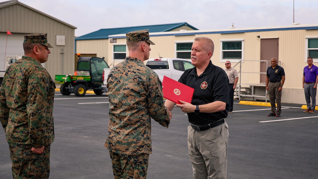 U.S. Marine Corps Col. Luke Watson, commanding officer of Blount Island Command, presents a certificate of commendation to Lt. Shawn Hall of the Jacksonville Fire and Rescue Department during a ceremony Feb. 13 at Marine Corps Support Facility Blount Island in Jacksonville, Florida. Watson commended his 15 years of collaboration with the Marine Corps facility's incident management team, emergency operations center and police department. His partnership was praised as instrumental in the success of numerous exercises, drills and training events.