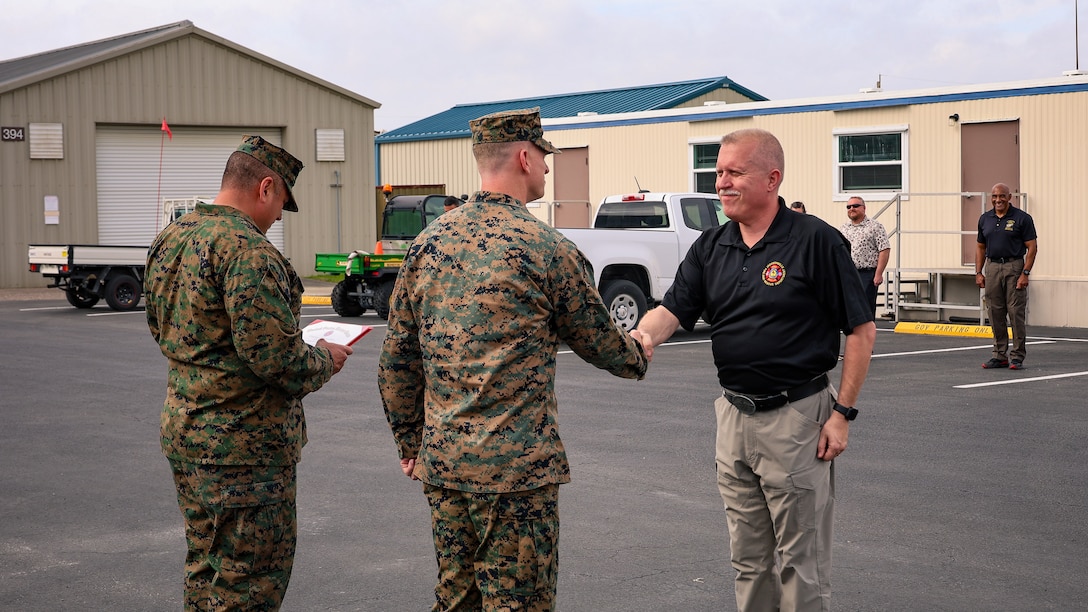 U.S. Marine Corps Col. Luke Watson, commanding officer of Blount Island Command, presents a certificate of commendation to Lt. Shawn Hall of the Jacksonville Fire and Rescue Department during a ceremony Feb. 13 at Marine Corps Support Facility Blount Island in Jacksonville, Florida. Watson commended his 15 years of collaboration with the Marine Corps facility's incident management team, emergency operations center and police department. His partnership was praised as instrumental in the success of numerous exercises, drills and training events.