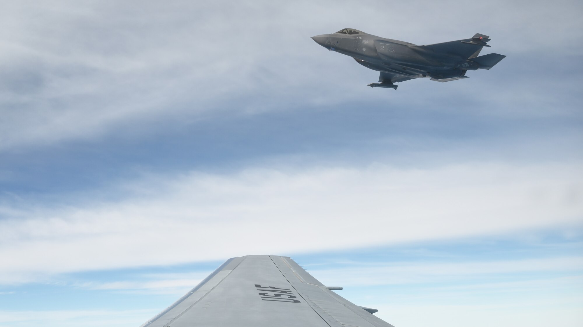 An F-35 Lightning II hovers outside a the wing of a KC-46A Pegasus assigned to McConnell Air Force Base, Kansas, and flown by an 931st Air Refueling Wing aircrew, the Reserve Unit at Team McConnell, over the skies of Guam.
