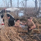 U.S. Navy Seabees assigned to Naval Mobile Construction Battalion (NMCB) 11 recover personal effects from a submerged vehicle after carrying its occupants to safety outside of New Orleans.