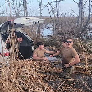 U.S. Navy Seabees assigned to Naval Mobile Construction Battalion (NMCB) 11 recover personal effects from a submerged vehicle after carrying its occupants to safety outside of New Orleans.