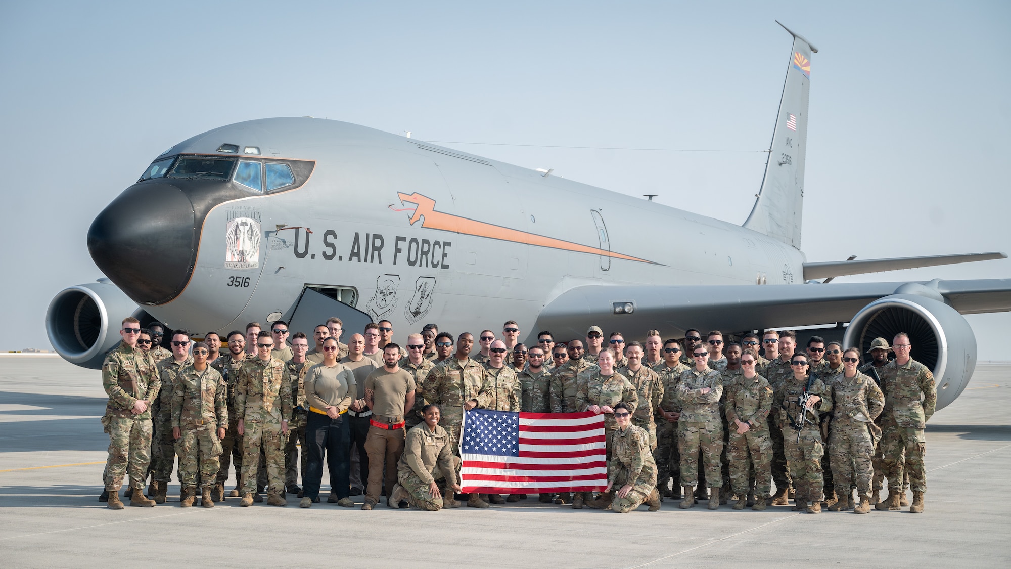 Airmen pose for a group photo in front of a KC-135