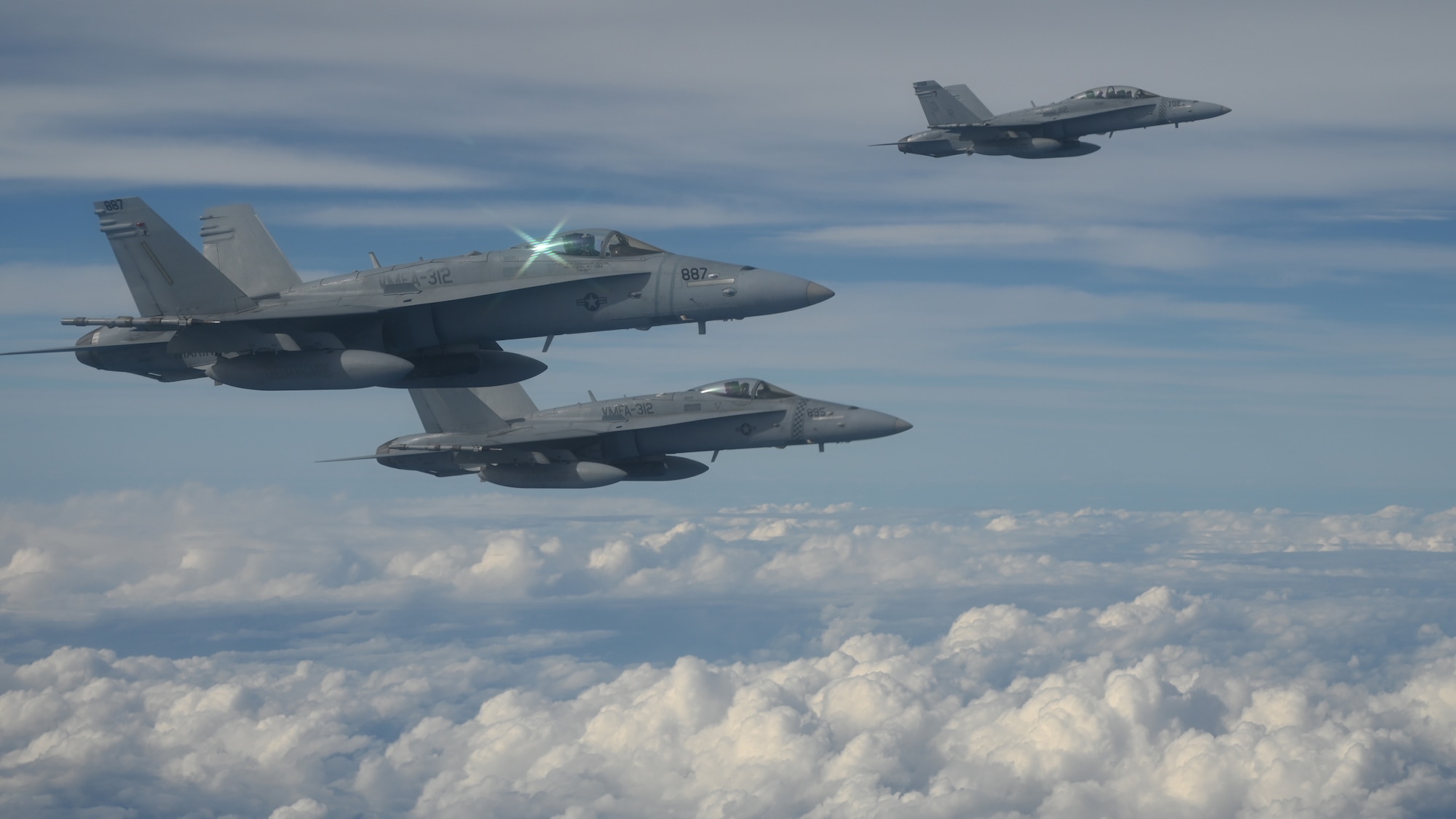 Three F/A-18D Hornet aircraft hover outside a the wing of a KC-46A Pegasus assigned to McConnell Air Force Base, Kansas, and flown by an 931st Air Refueling Wing aircrew, the Reserve Unit at Team McConnell, over the skies of Guam, Feb. 5, 2025.