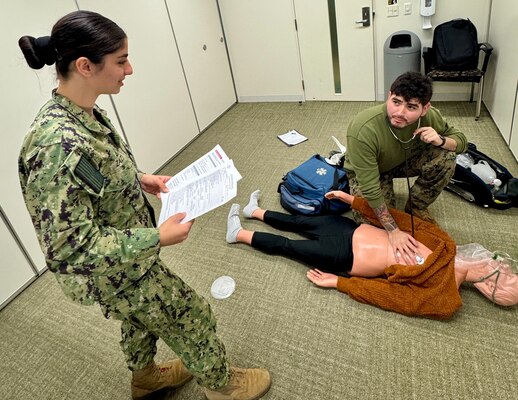 HM3 Nessa Zazi evaluates while HM3 Jason Veloz conducts a simulated contact with a sick patient in need of medical care.
