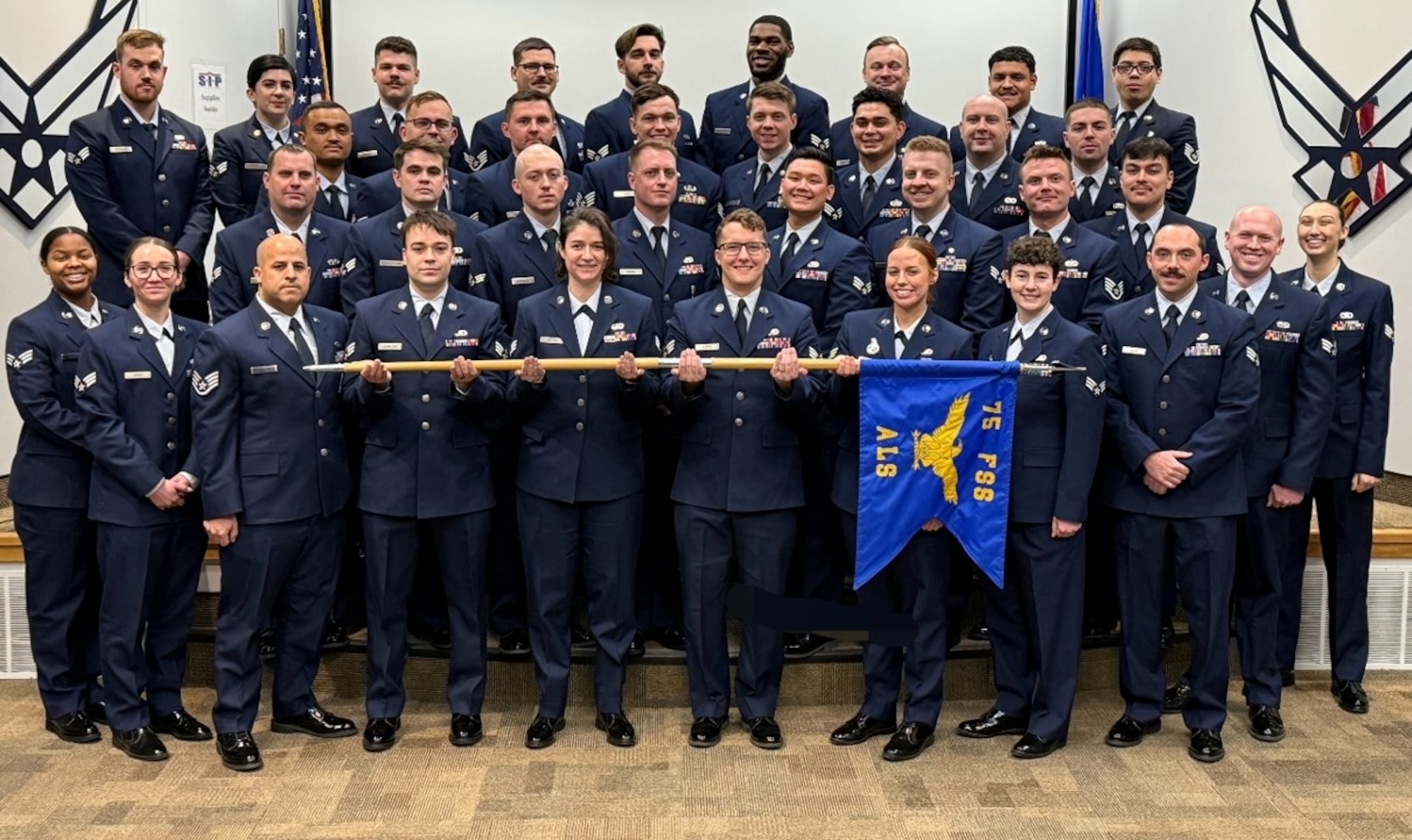 Airmen in dress blues stand in formation