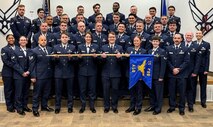 Airmen in dress blues stand in formation