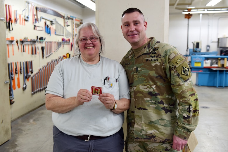 U.S. Army Corps of Engineers Command Sgt. Maj. Douglas Galick presents Deborah Greene, journeyman mechanic at the Wolf Creek Dam Powerhouse, with a coin recognizing excellence during a visit Feb. 11, 2025, to the project on the Cumberland River in Jamestown, Kentucky. Greene is in her 26th year of federal service. (USACE Photo by Lee Roberts)