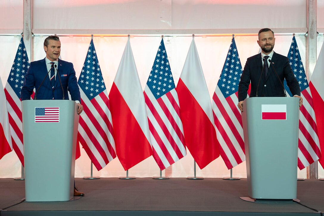 Defense Secretary Pete Hegseth and Polish defense minister stand behind lecterns with the flags of both countries in the background.