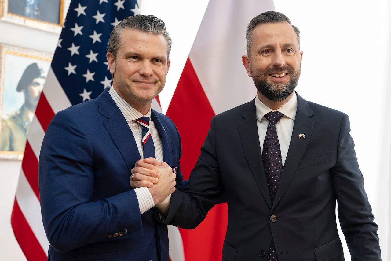 Defense Secretary Pete Hegseth holds fists with the Polish defense minister.