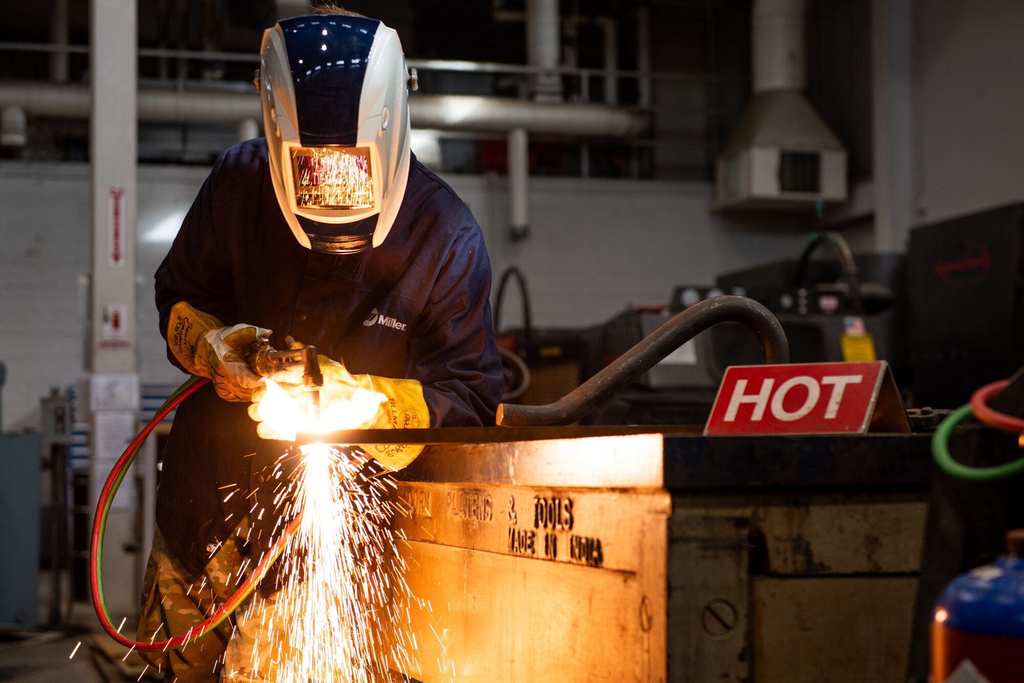 Airman cutting metal with torch
