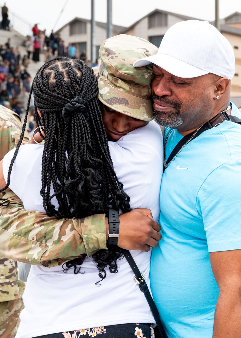 An Airman hugs family members following the 737th Training Group Coin and Retreat Ceremony