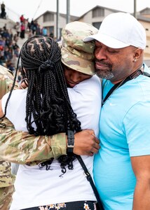 An Airman hugs family members following the 737th Training Group Coin and Retreat Ceremony