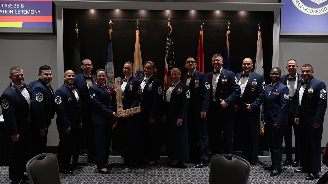 U.S. Air Force Senior Airman Lisa Botello, Airman Leadership School Class 25-B class lead, hands the “L” to Senior Master Sgt. Jessica Thompson, 17th Force Support Squadron senior enlisted leader, during the ALS Class 25-B graduation at the Powell Event Center, Goodfellow Air Force Base, Texas, Feb. 13, 2025. Every ALS class plays a volleyball game with the first sergeants and the winning team presents the “L” to the losing team at graduation. (U.S. Air Force photo by Senior Airman Madi Collier)