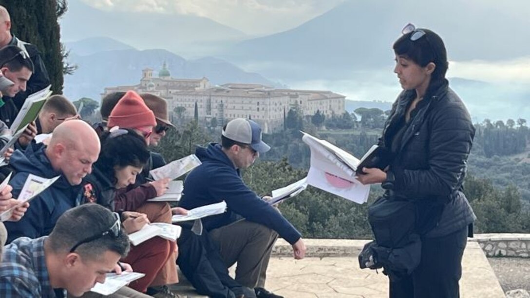 SAW European Staff Ride:  Maj May, USMC, leads a guided discussion focusing on the Feb-May 1944 pyrrhic Allied operations to seize high ground overlooking the Liri River Valley/Highway 6, which enabled the Allies to continue the attack to liberate Rome. Photo taken from peak of hill 593 with the Abbey of Monte Cassino and the Liri River Valley in the background.