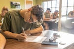 A U.S. Marines with Combat Logistics Battalion 22, Combat Logistics Regiment 27, 2nd Marine Logistics Group, takes notes during spiritual health training held at the 2nd MLG Human Performance on Camp Lejeune, North Carolina, Sept. 18, 2024. The HPC is conducting a 12-week program consisting of initial baseline assessments, surveys, and in-briefs with the remaining weeks spent on physical training sessions and classes to help CLB-22 improve in all domains of Marine Corps Total Fitness.