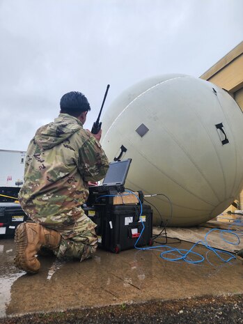 man kneeling in front of equipment
