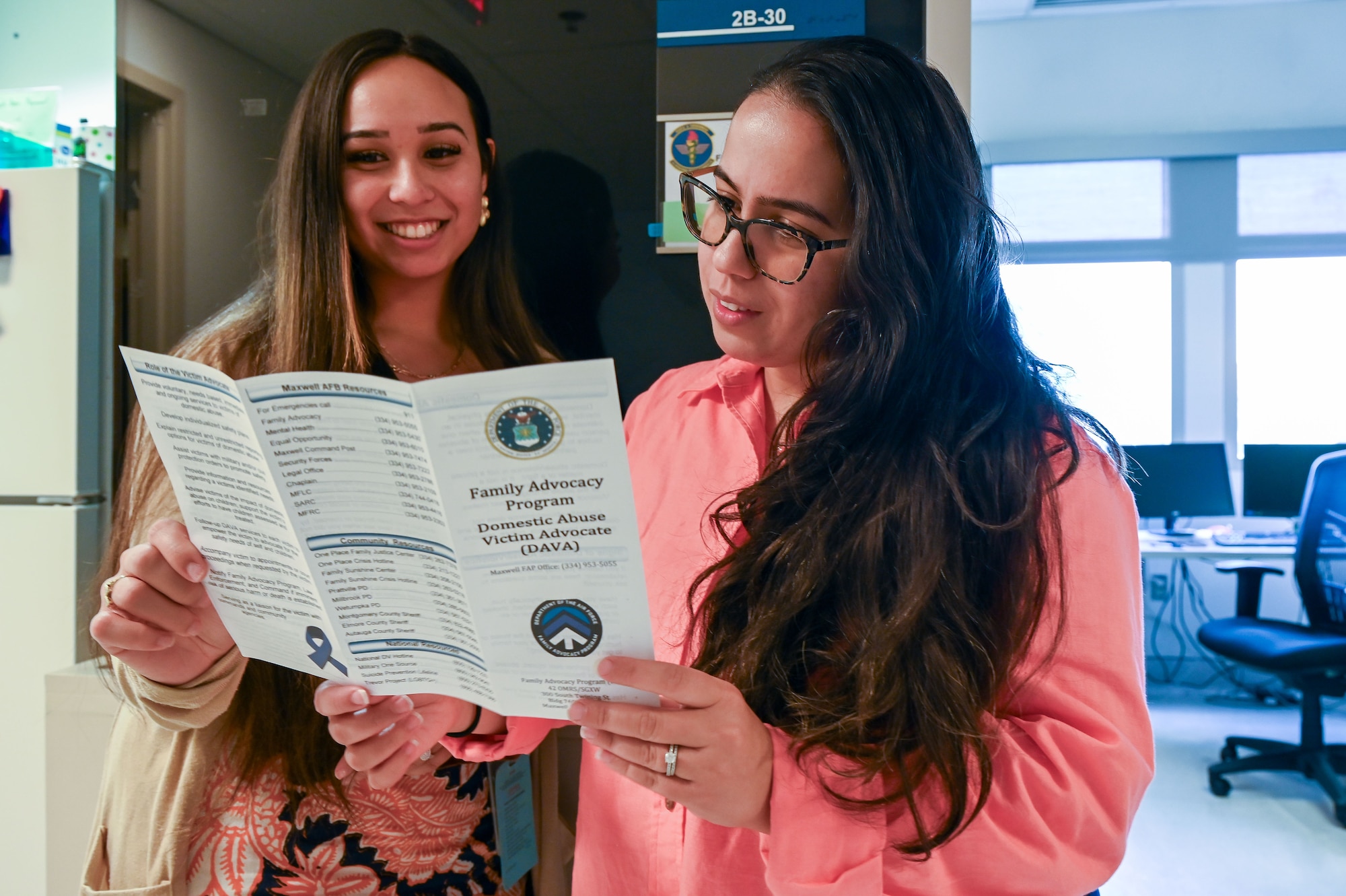Linda M. Pena-Resto, right, 42nd Medical Group family advocacy officer, reads a Domestic Abuse Victim Advocate pamphlet with Anjali Ali, 42nd Medical Group DAVA at Maxwell Air Force Base, Alabama, Feb.11, 2025.