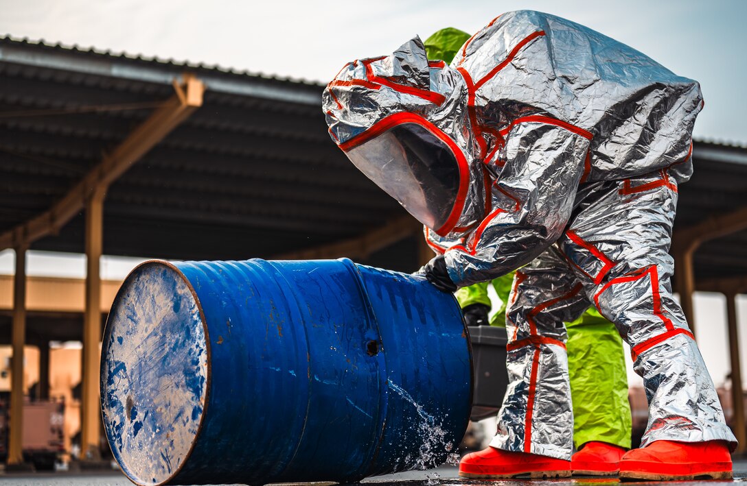 Airman in hazmat suit with barrel
