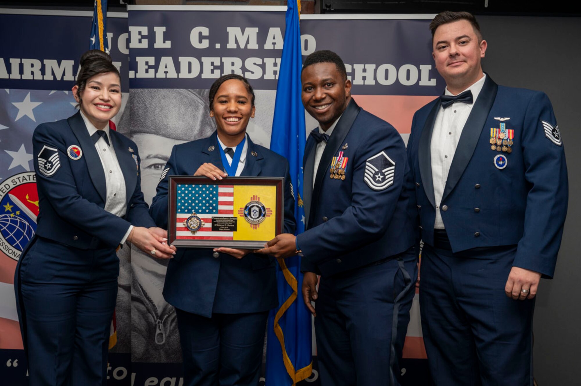 U.S. Air Force Staff Sgt. D’Nahrya Sutton, center, Airman Leadership Graduate, accepts the Commandant’s Award from U.S. Air Force Master Sgt. Cecilia Ayon, 49th Force Support Squadron ALS commandant, left, during the graduation of Joel C. Mayo Class 25-B at Holloman Air Force Base, New Mexico, Feb. 7, 2025. The Commandant’s award is selected by the ALS commandant and is presented to the student who best demonstrates the characteristics of an effective leader. (U.S. Air Force photo by Senior Airman Michelle Ferrari)