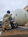 man kneeling in front of equipment
