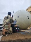 man kneeling in front of equipment