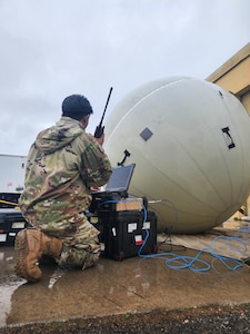 man kneeling in front of equipment
